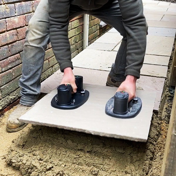 man using two grabos to lay the natural stone paving sandstone