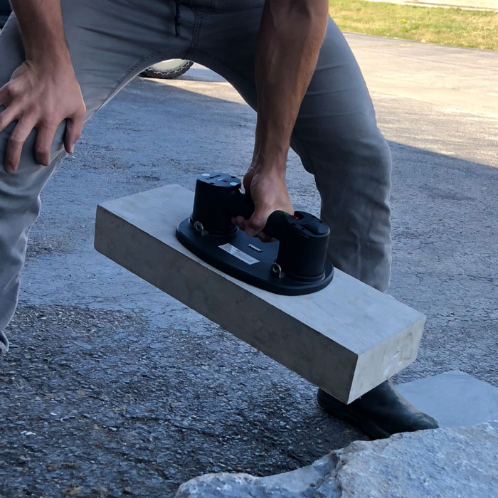 man using electric grabo plus heavy-duty suction pad heavy-duty suction pads to lift big concrete kerb